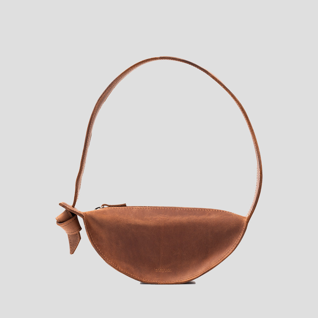 Crescent Cognac Brown Shoulder Bag with adjustable strap and elegant half-moon design, showcasing its durable leather craftsmanship.