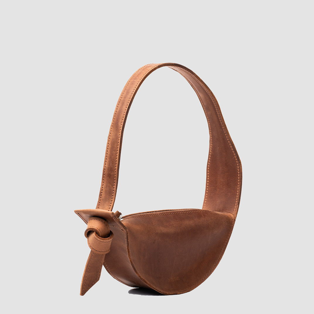 Crescent Cognac Brown Shoulder Bag with adjustable strap and elegant half-moon design, showcasing its durable leather craftsmanship.