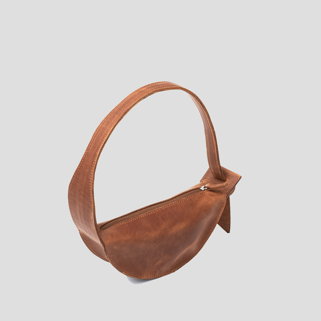 Crescent Cognac Brown Shoulder Bag with adjustable strap and elegant half-moon design, showcasing its durable leather craftsmanship.