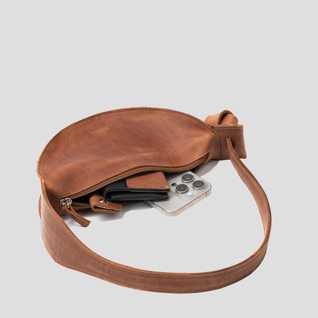 Crescent Cognac Brown Shoulder Bag with adjustable strap and elegant half-moon design, showcasing its durable leather craftsmanship.