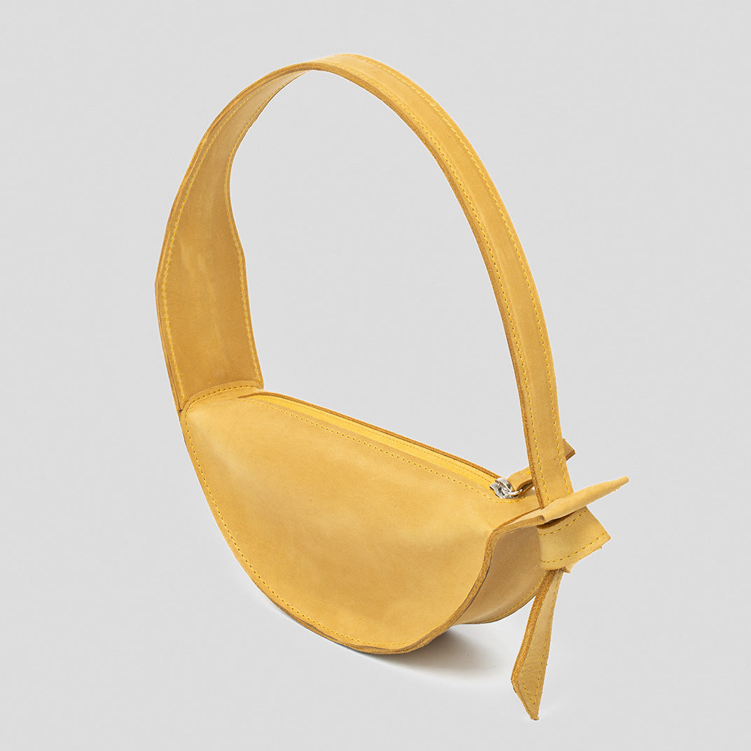 Crescent Yellow Shoulder Bag featuring a half-moon design, adjustable strap, and durable leather construction.