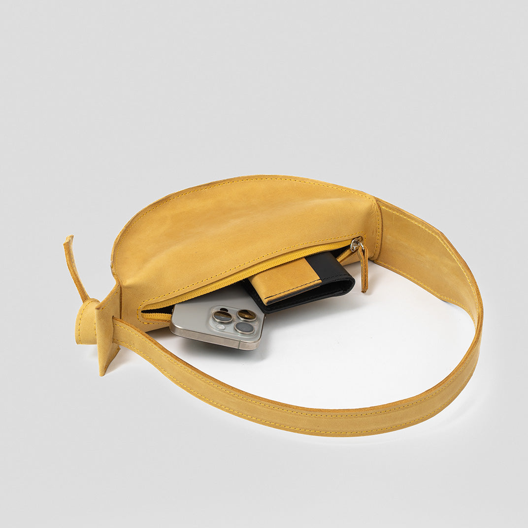 Crescent Yellow Shoulder Bag featuring a half-moon design, adjustable strap, and durable leather construction.