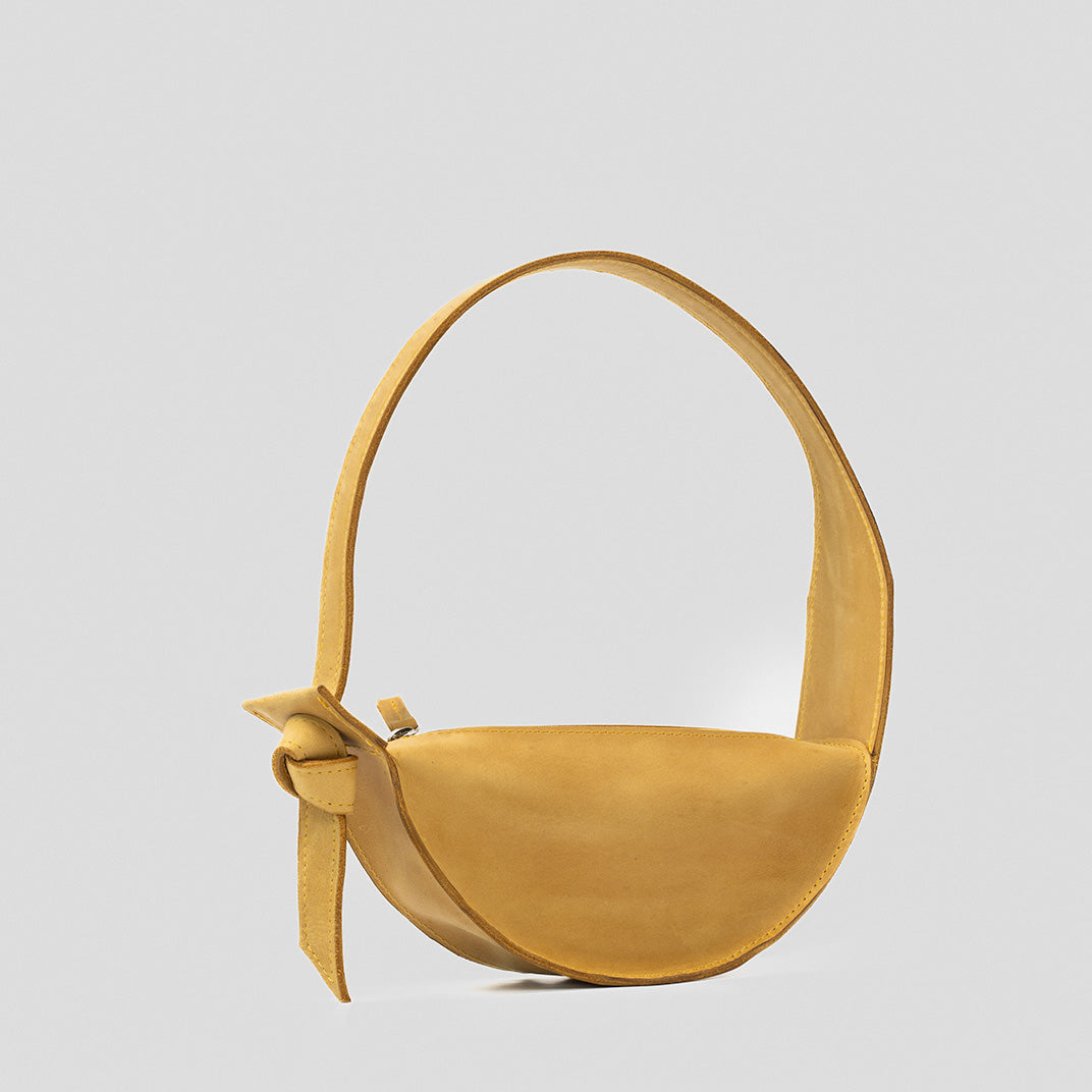 Crescent Yellow Shoulder Bag featuring a half-moon design, adjustable strap, and durable leather construction.