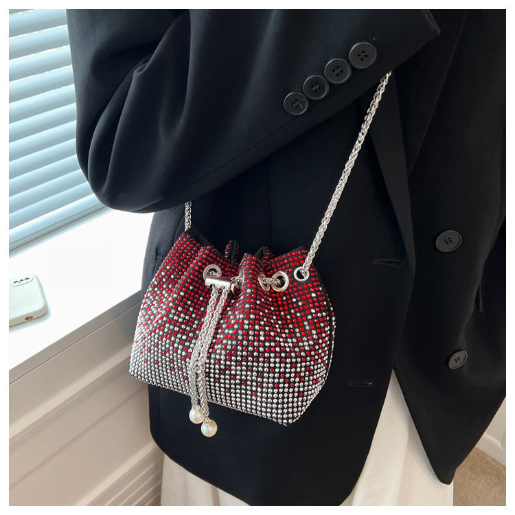 Small crossbody bag featuring a diamond chain handle, made of fabric and rhinestone, perfect for stylish outings.