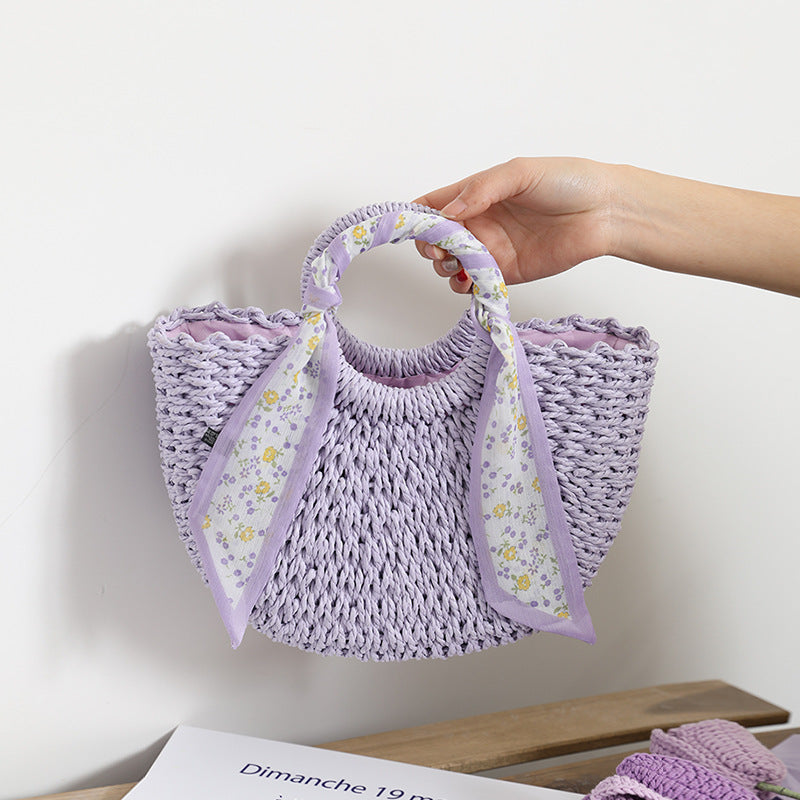 SolunaWeave™ Petite Bloom Bag featuring handwoven lavender and cream straw with a floral silk scarf, perfect for elegant outings.