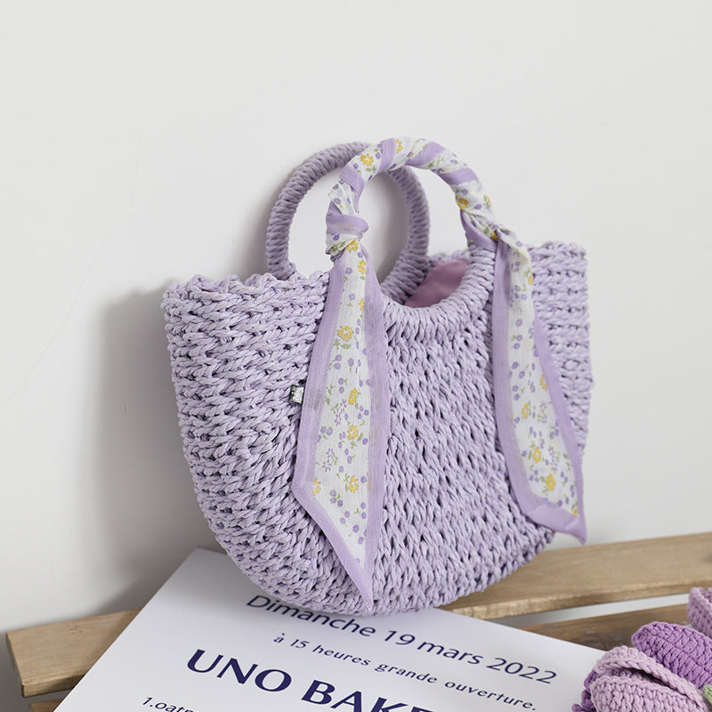 SolunaWeave™ Petite Bloom Bag featuring handwoven lavender and cream straw with a floral silk scarf, perfect for elegant outings.