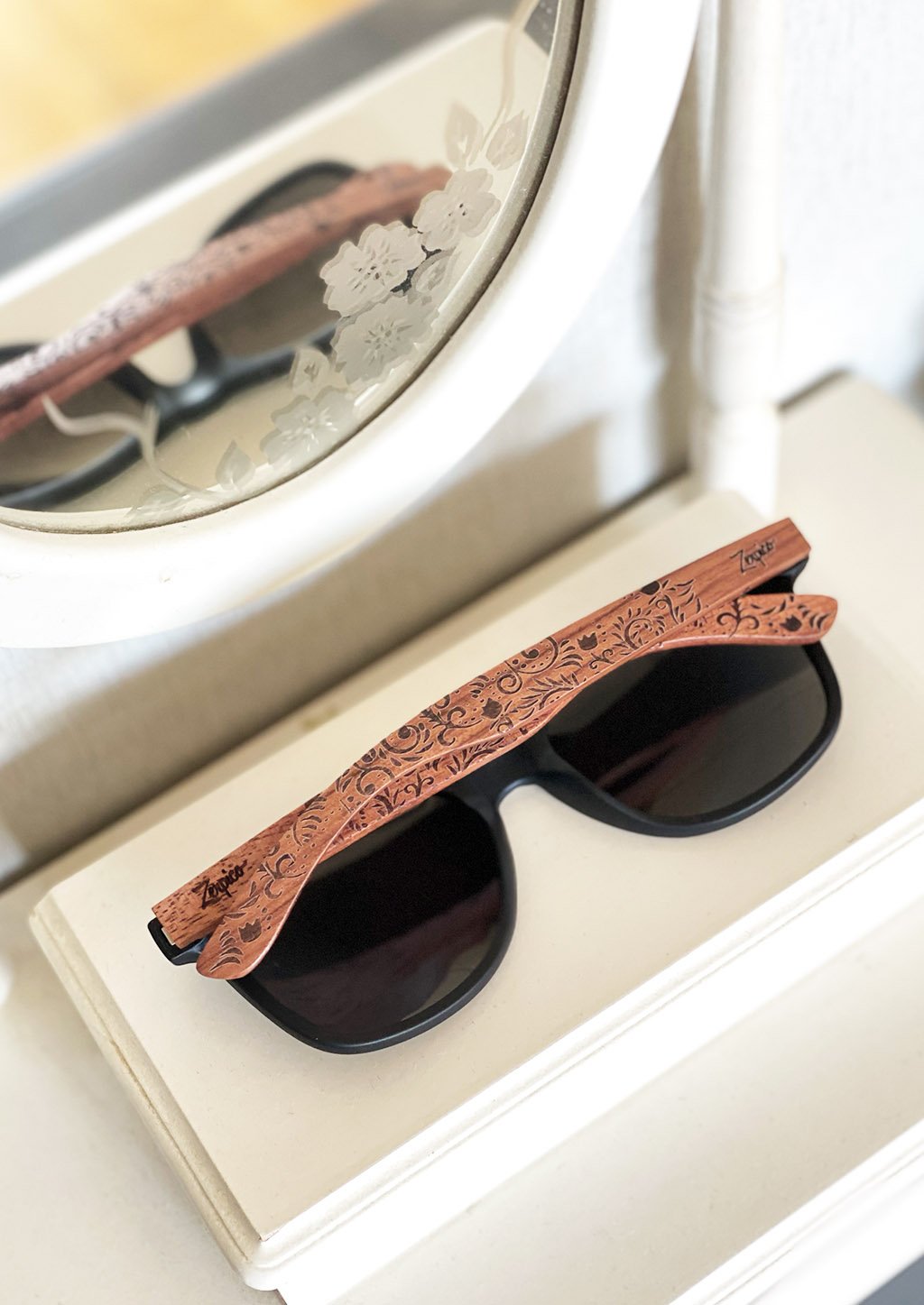 Eyewood engraved wooden sunglasses made from rosewood with a flower pattern, showcasing polarized black lenses and stainless steel hinges.