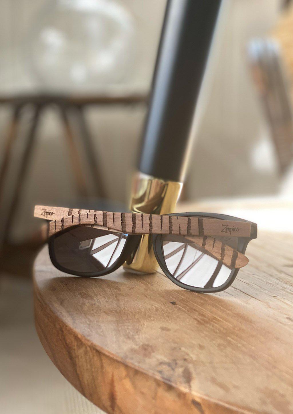 Eyewood Untamed engraved wooden sunglasses featuring unique tiger patterns on walnut temples and polarized black lenses.