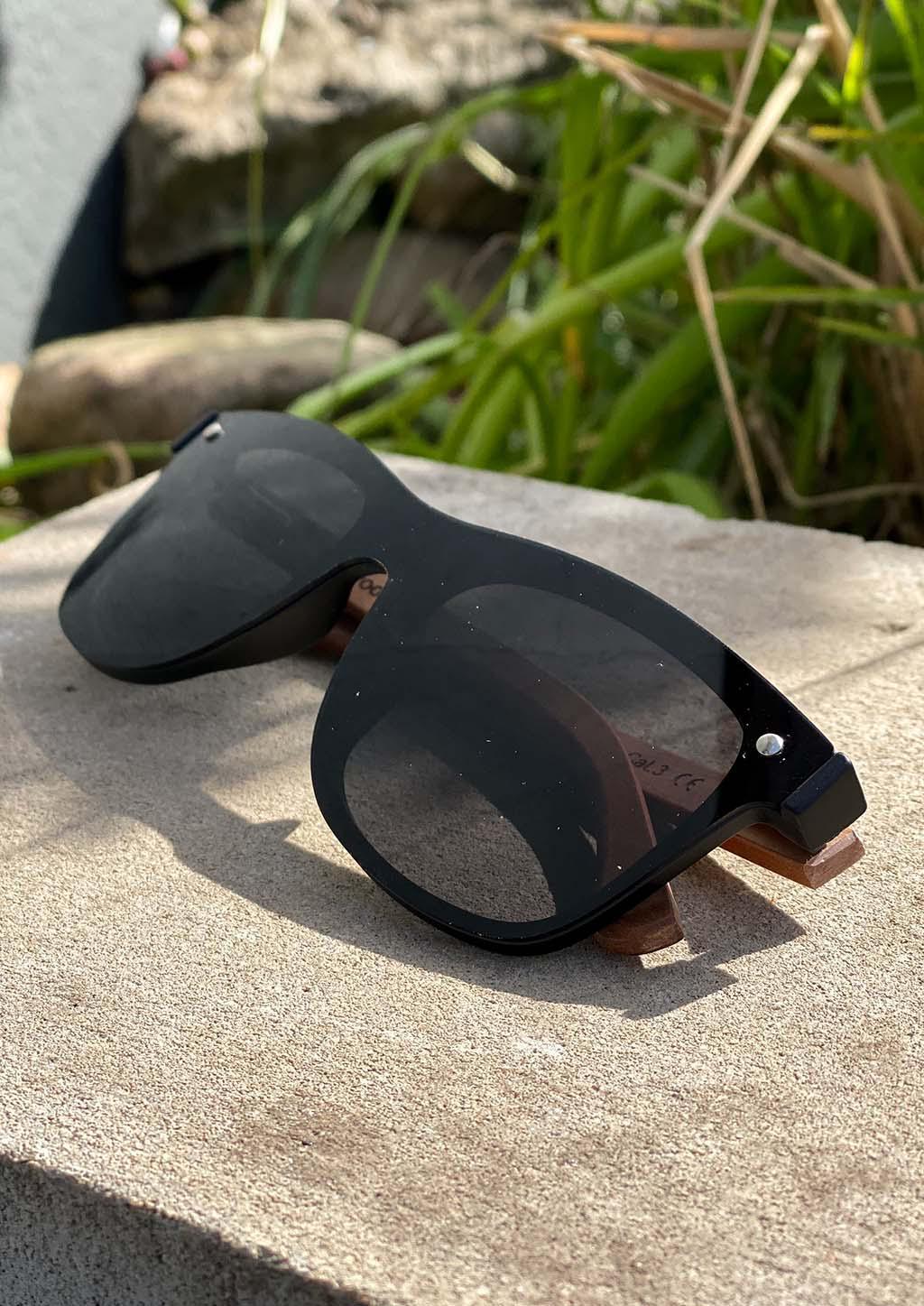 Eyewood Tomorrow - Taurus wooden sunglasses featuring rosewood frame and polarized black lenses, elegantly displayed in a handmade empress tree case.