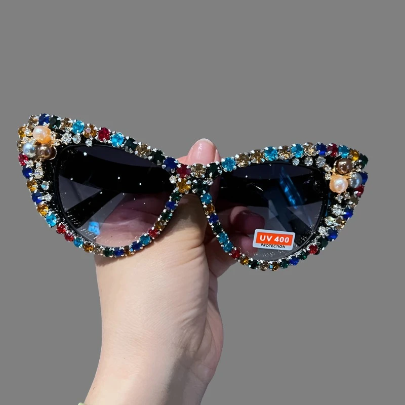 Hand designed bejeweled sunglasses with oversized cat eye style, featuring plastic frames and UV400 lenses.