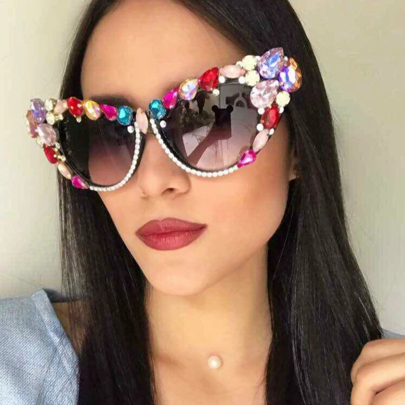 Hand designed bejeweled sunglasses with oversized cat eye style, featuring plastic frames and UV400 lenses.