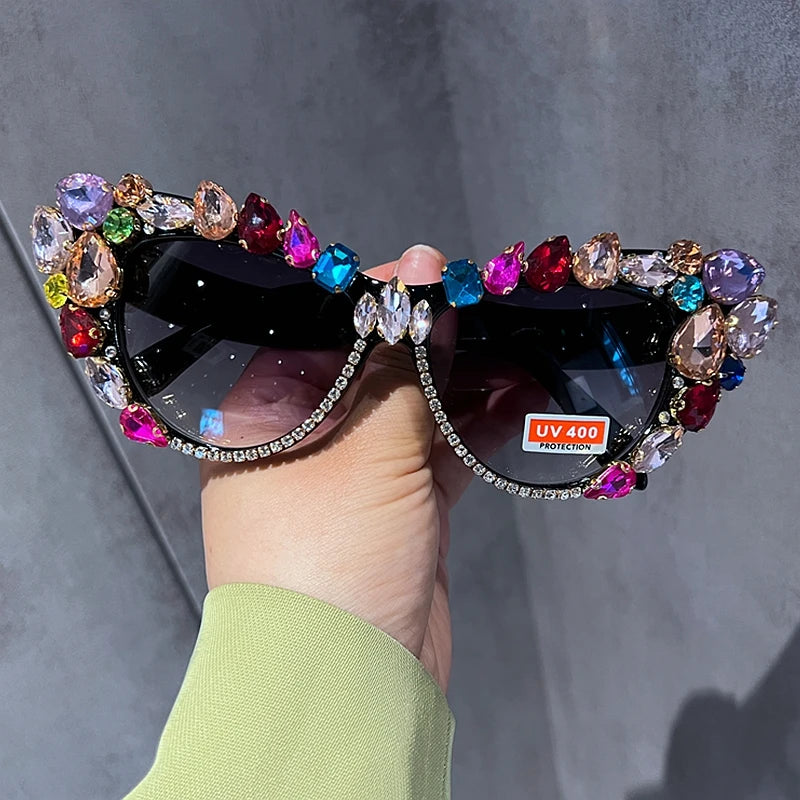Hand designed bejeweled sunglasses with oversized cat eye style, featuring plastic frames and UV400 lenses.