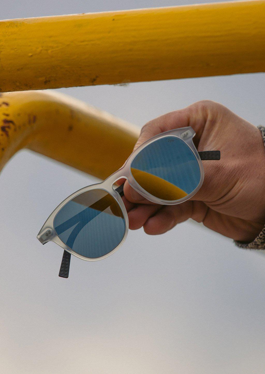 Hybrid Halo sunglasses featuring a round design with carbon fiber and acetate materials, showcasing various lens colors.