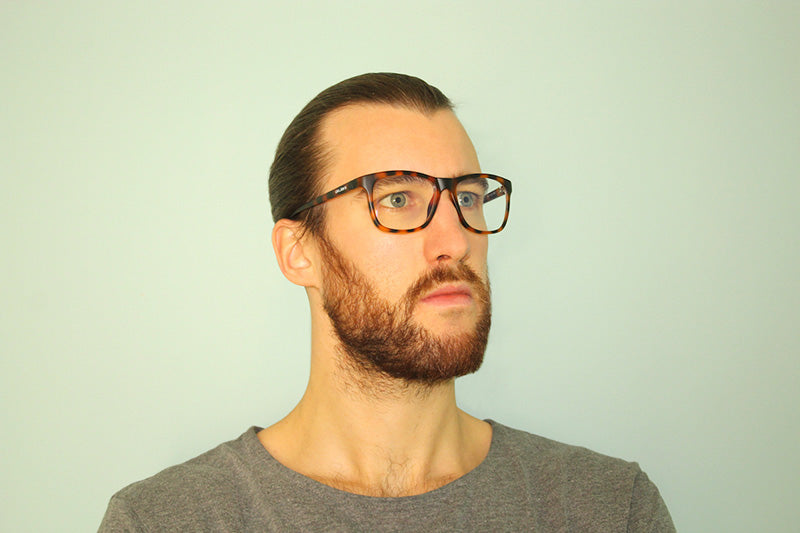 Okulars Eco Nordic Luce Blu - Sand glasses with a matte finish, displayed with a velvet case and cleaning cloth.