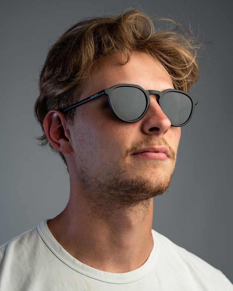 Okulars Eco Pacific Black sunglasses with a sleek matte finish, made from recycled materials, displayed on a neutral background.