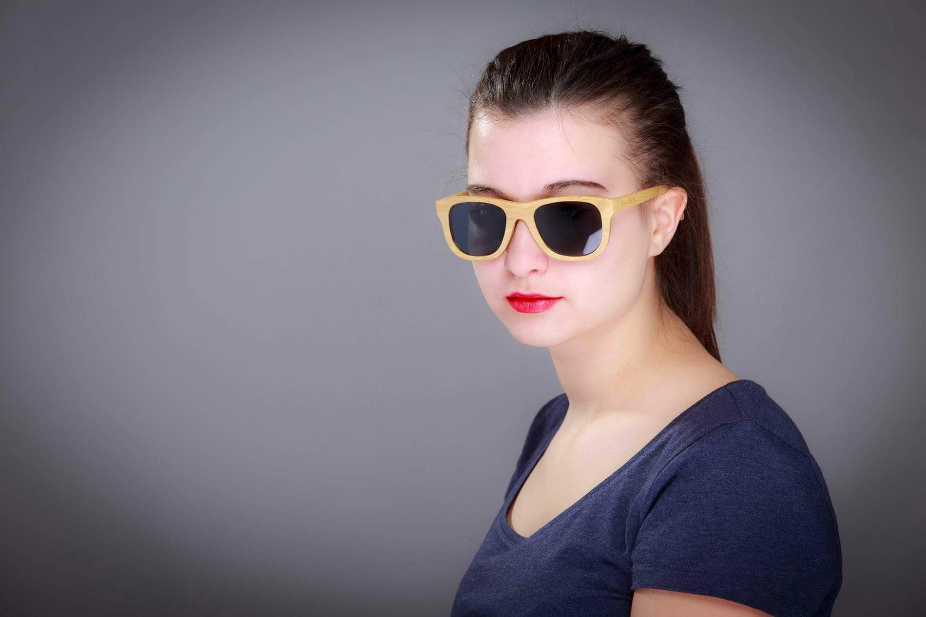 Okulars® Natural Bamboo sunglasses in Coal Black, featuring a lightweight bamboo frame and polarized lenses, displayed elegantly.