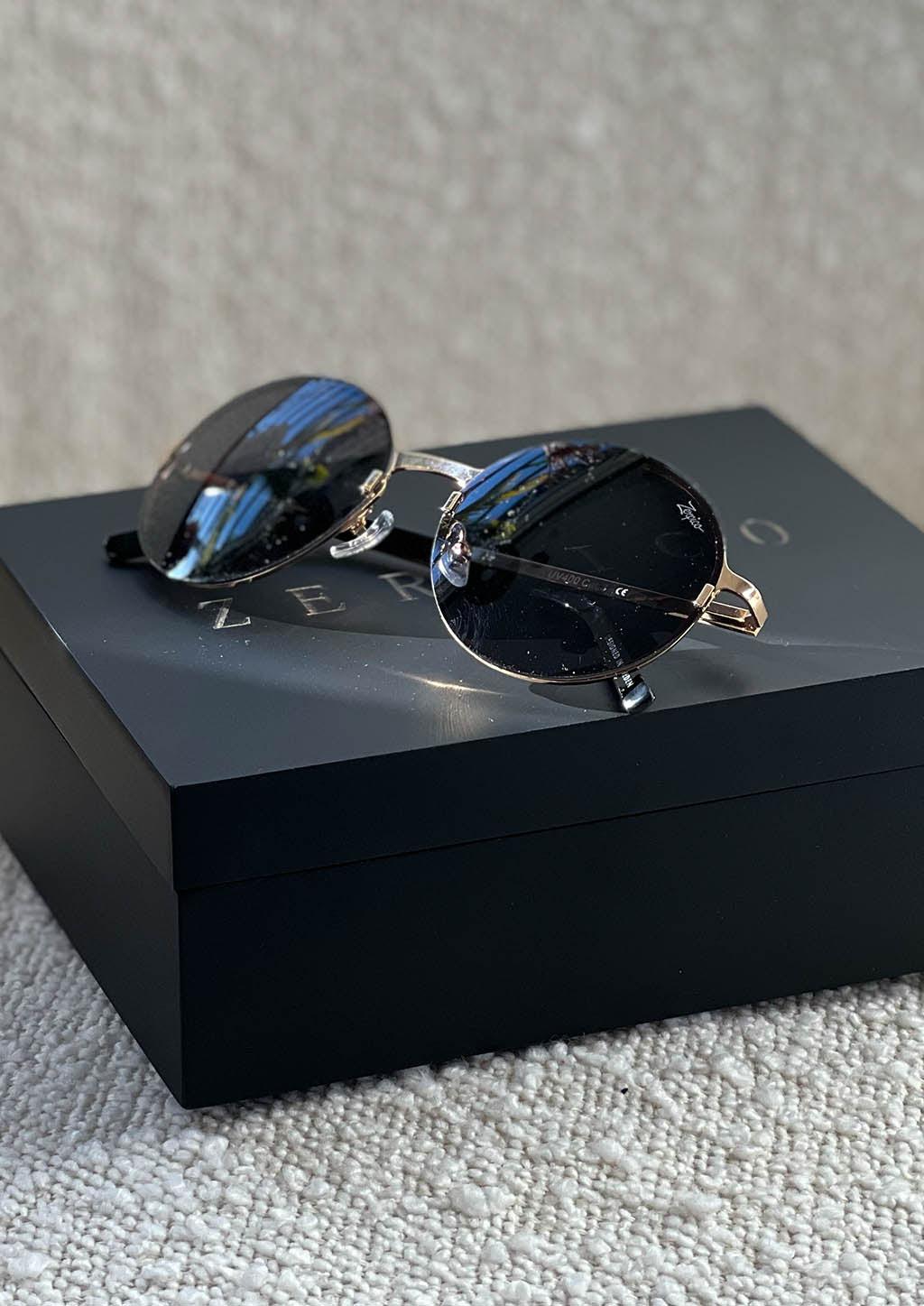 Luxurious titanium round sunglasses with 24K gold plating and interchangeable lenses, showcasing a stylish and elegant design.