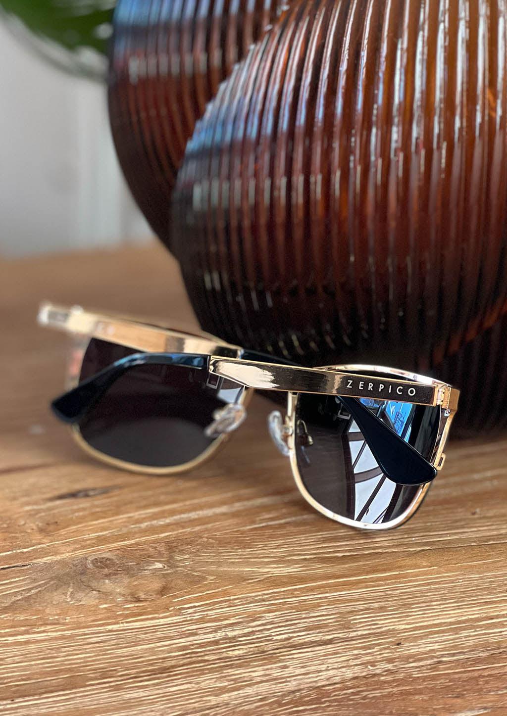 Luxurious Titanium Wayfarer Sunglasses plated with 24K gold, showcasing a stylish design and changeable lenses.