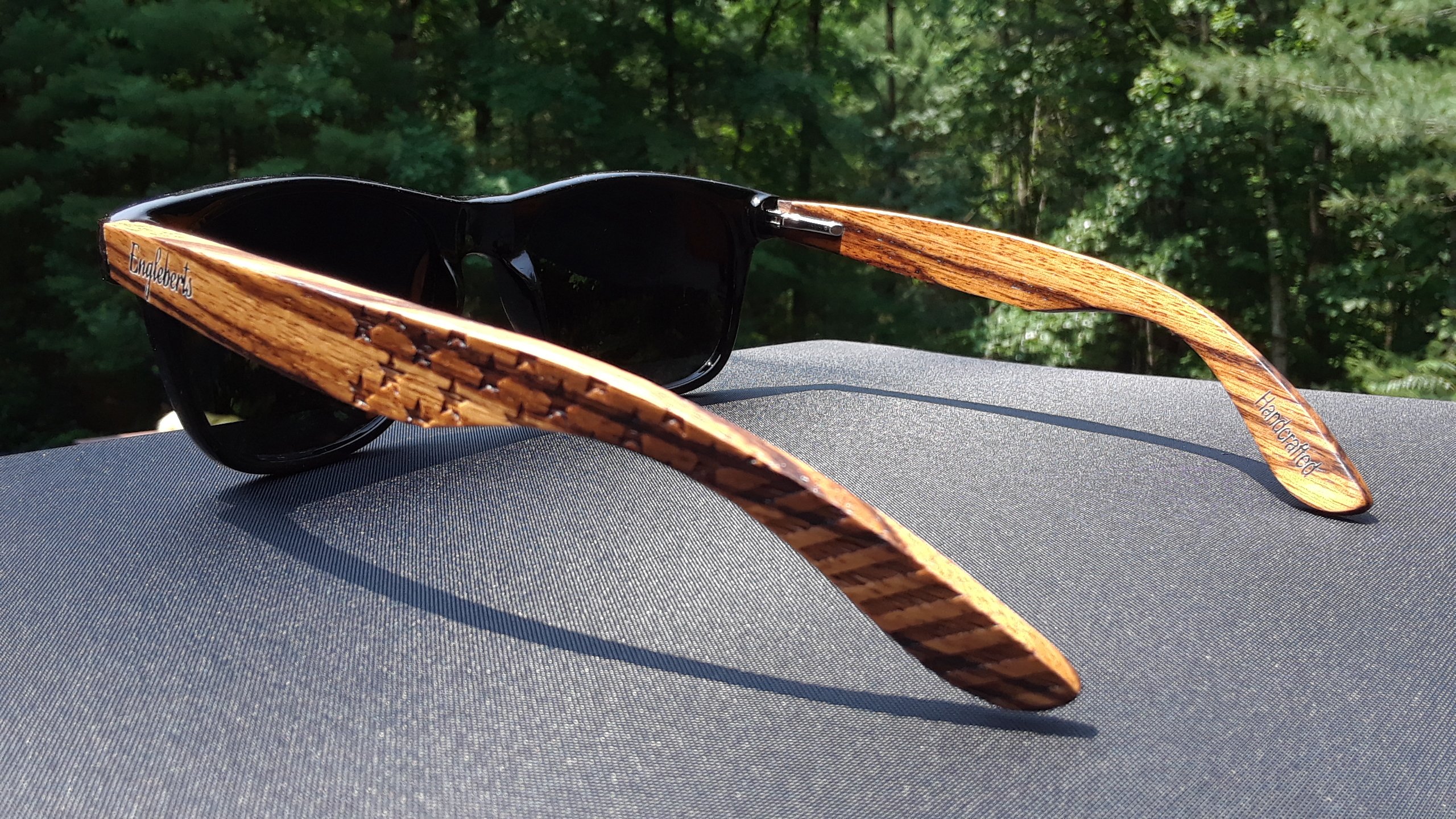 Handcrafted Zebrawood sunglasses with polarized lenses, featuring artisan engraving and eco-friendly design.