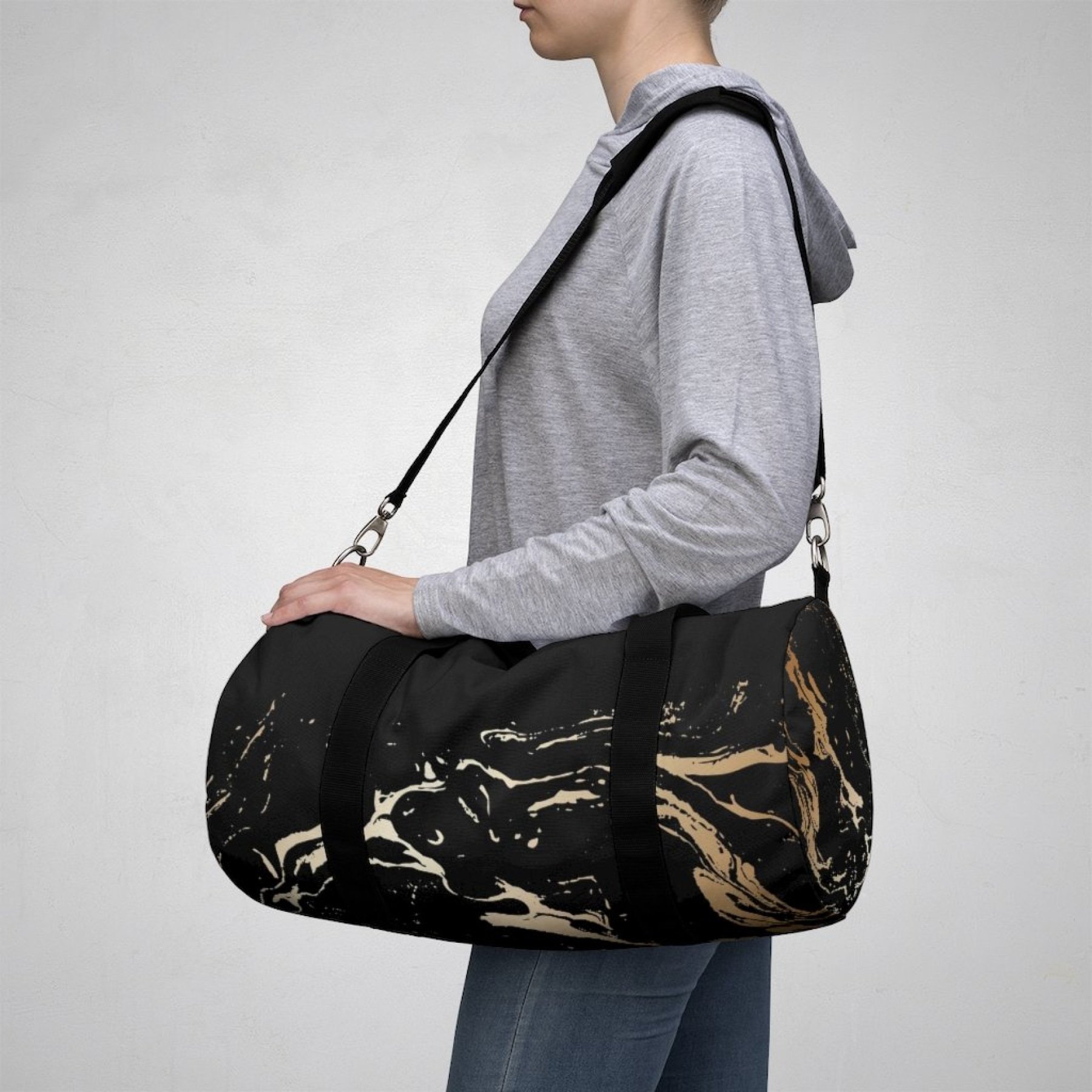 Stylish black and gold duffel bag made of soft nylon, perfect for gym and travel.