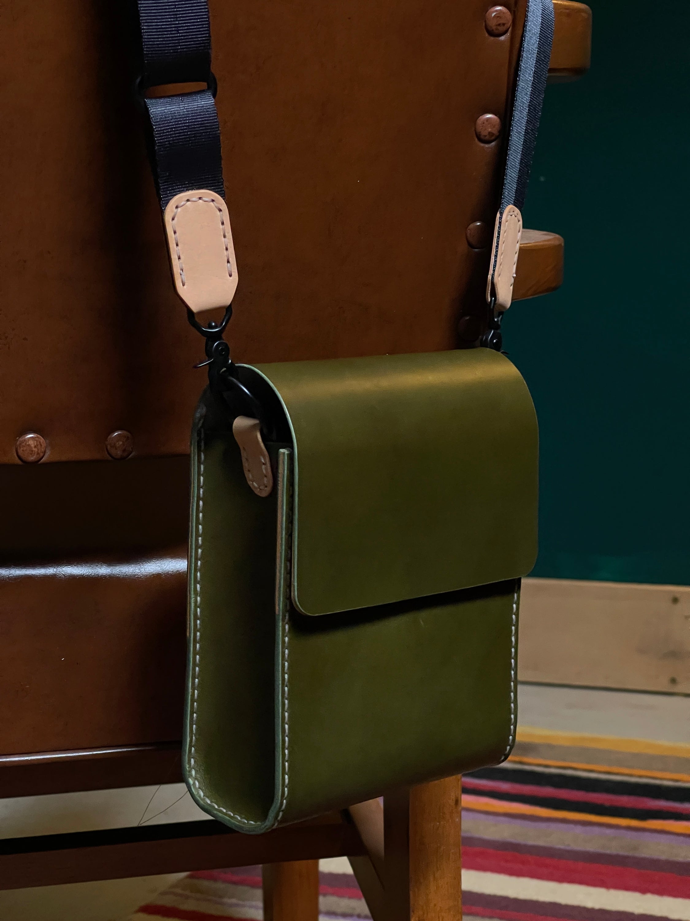Giramondo Leather Crossbody Bag in Olive and Natural colors, showcasing full grain leather and matte black hardware.