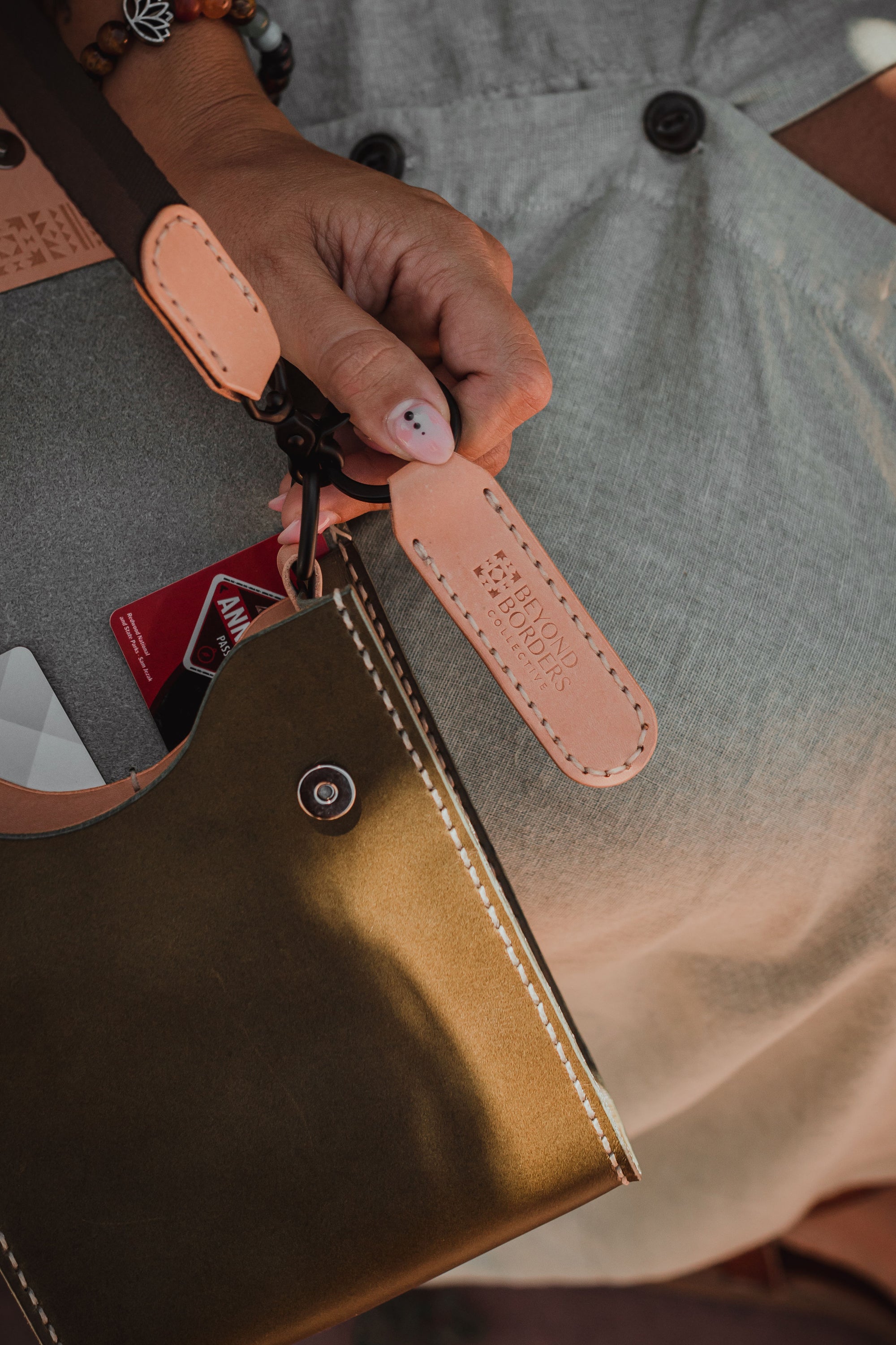 Giramondo Leather Crossbody Bag in Olive and Natural colors, showcasing full grain leather and matte black hardware.