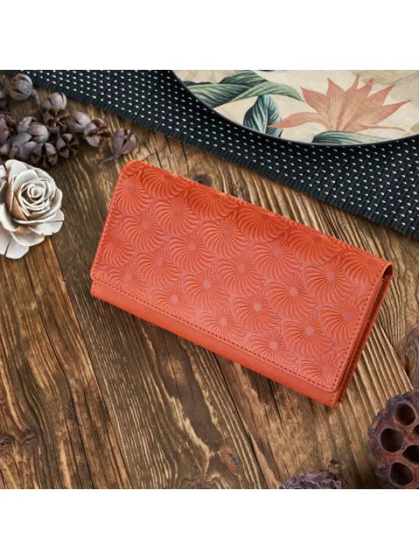 Natural leather women's wallet in red, green, and orange with geometric embossed pattern and compartments for cards and cash.