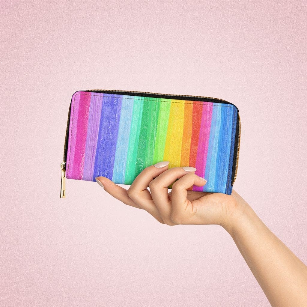 Colorful women's zip wallet featuring a rainbow stripe pastel design, made from cruelty-free faux leather with gold stitching.