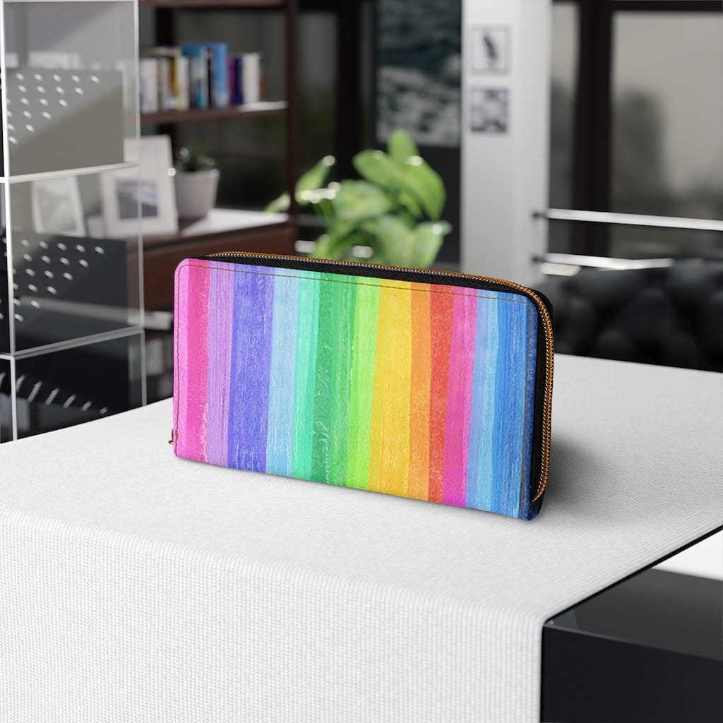 Colorful women's zip wallet featuring a rainbow stripe pastel design, made from cruelty-free faux leather with gold stitching.