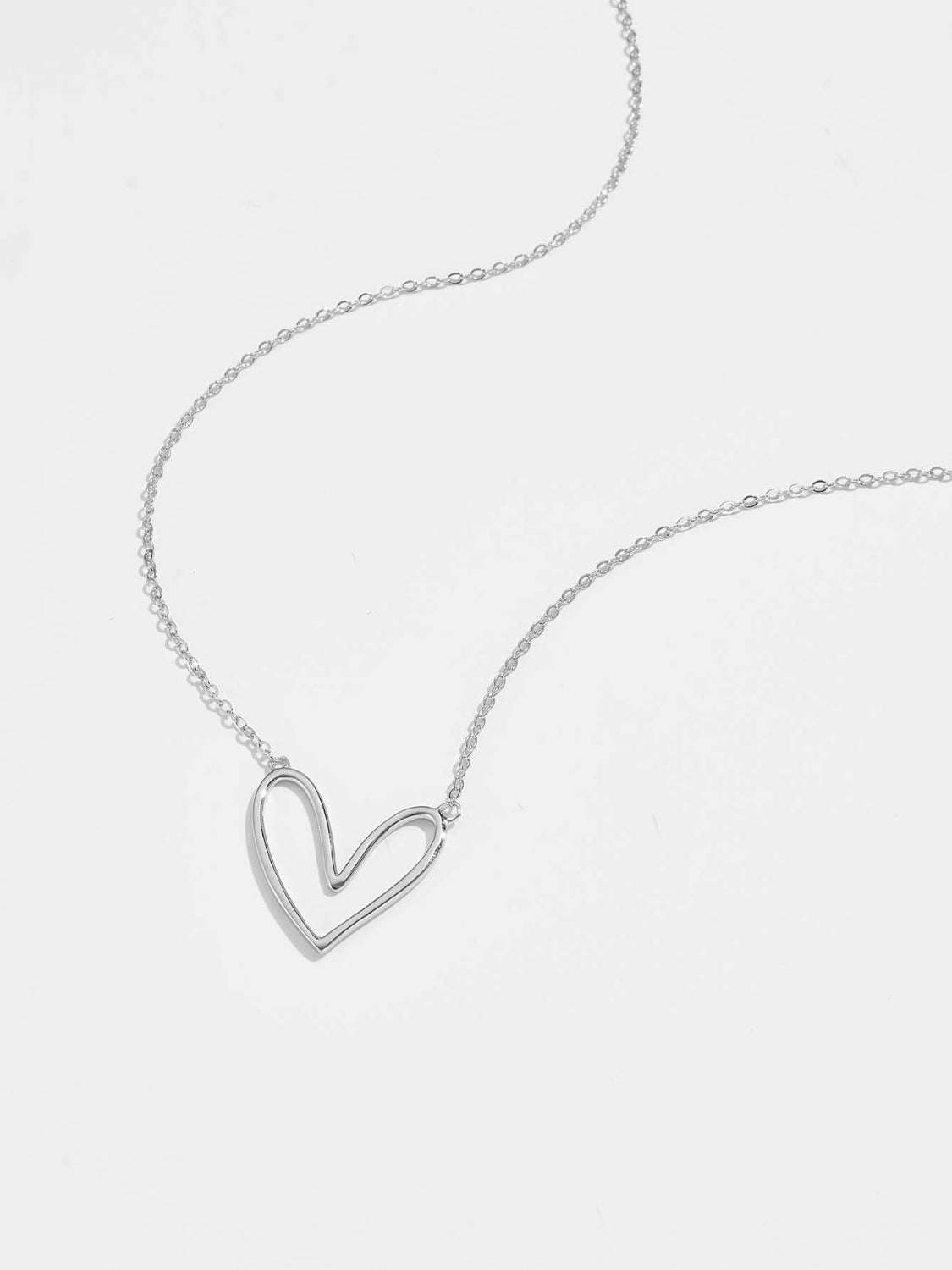 A delicate 925 sterling silver heart pendant necklace with a platinum and 18K gold plating, showcasing its elegant design.