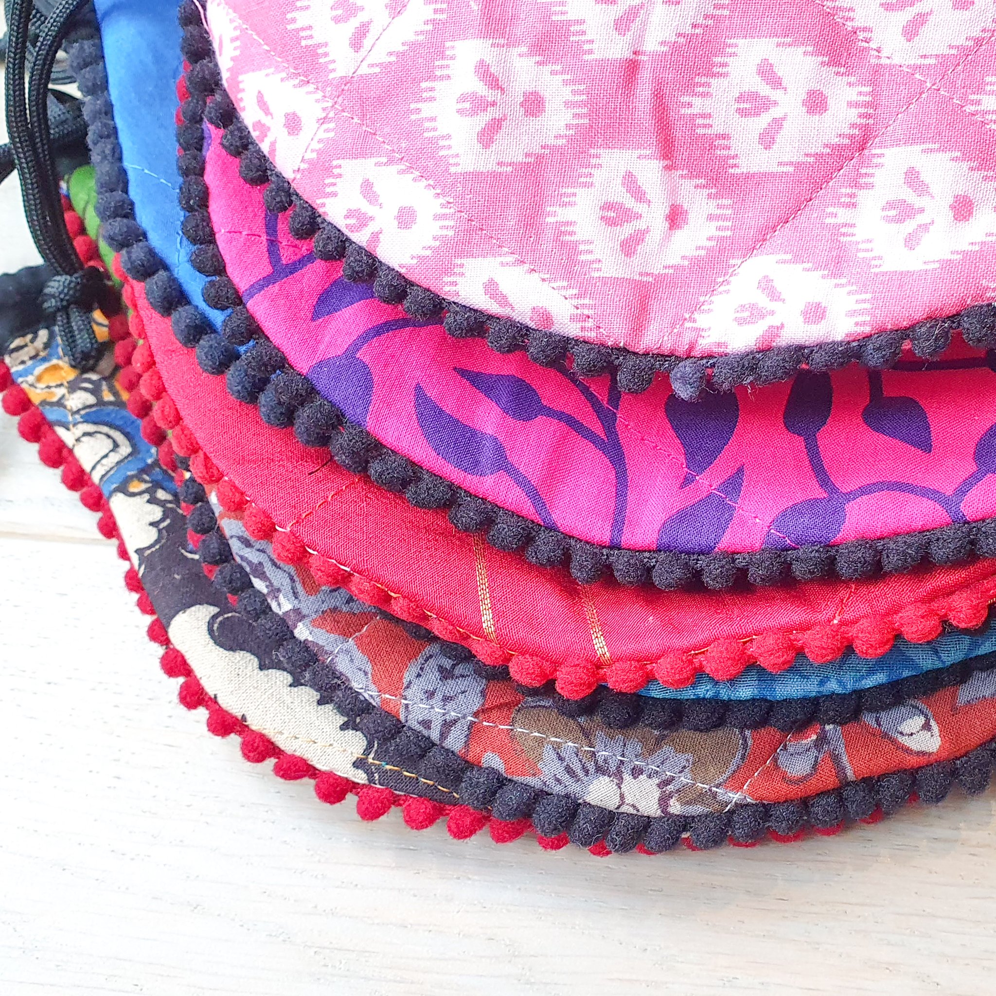 A colorful handcrafted drawstring sari pouch showcasing unique patterns and vibrant colors, perfect for storing small items.