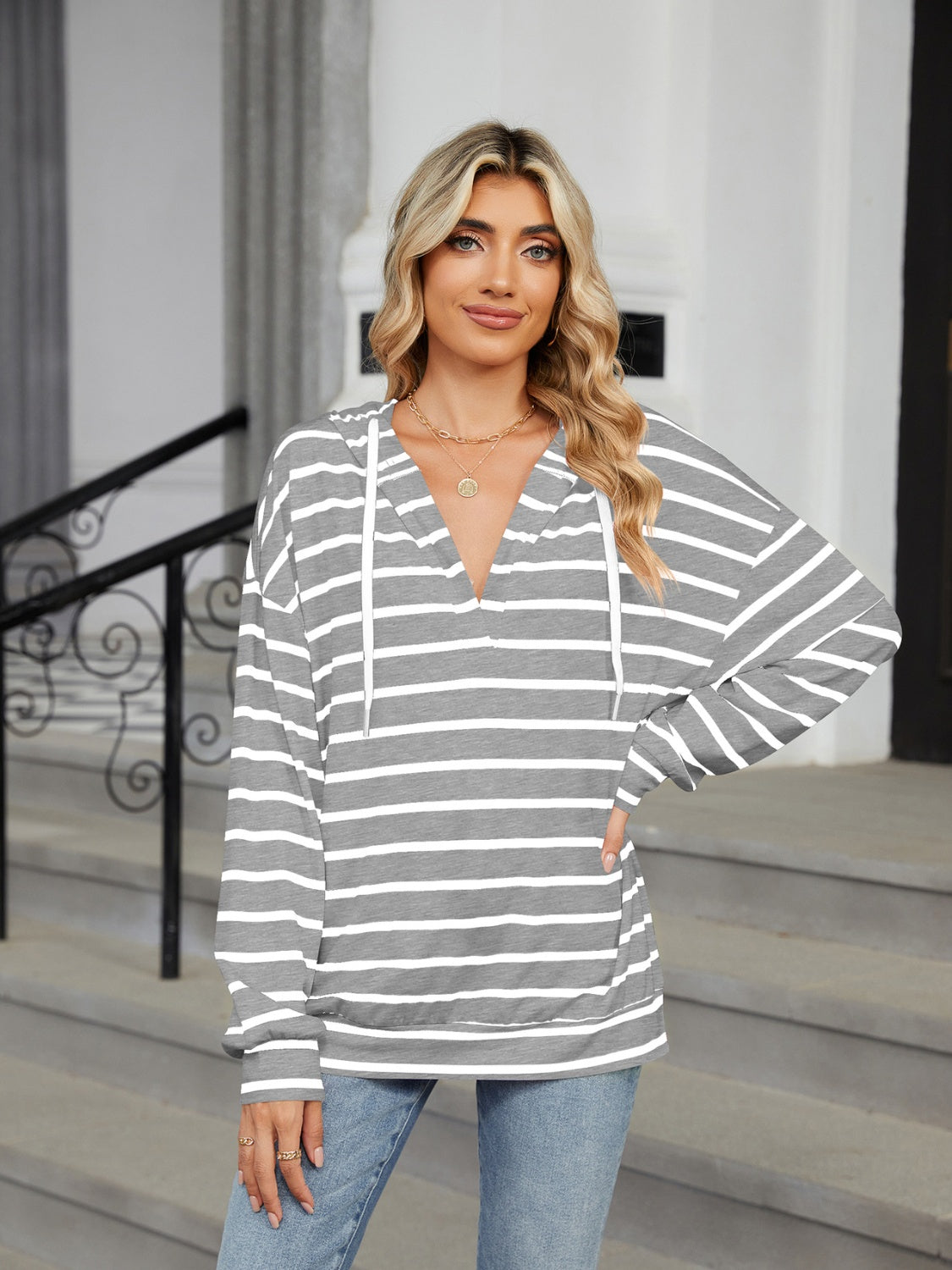 A stylish drawstring striped long sleeve hoodie in various colors, showcasing its soft fabric and adjustable drawstring feature.