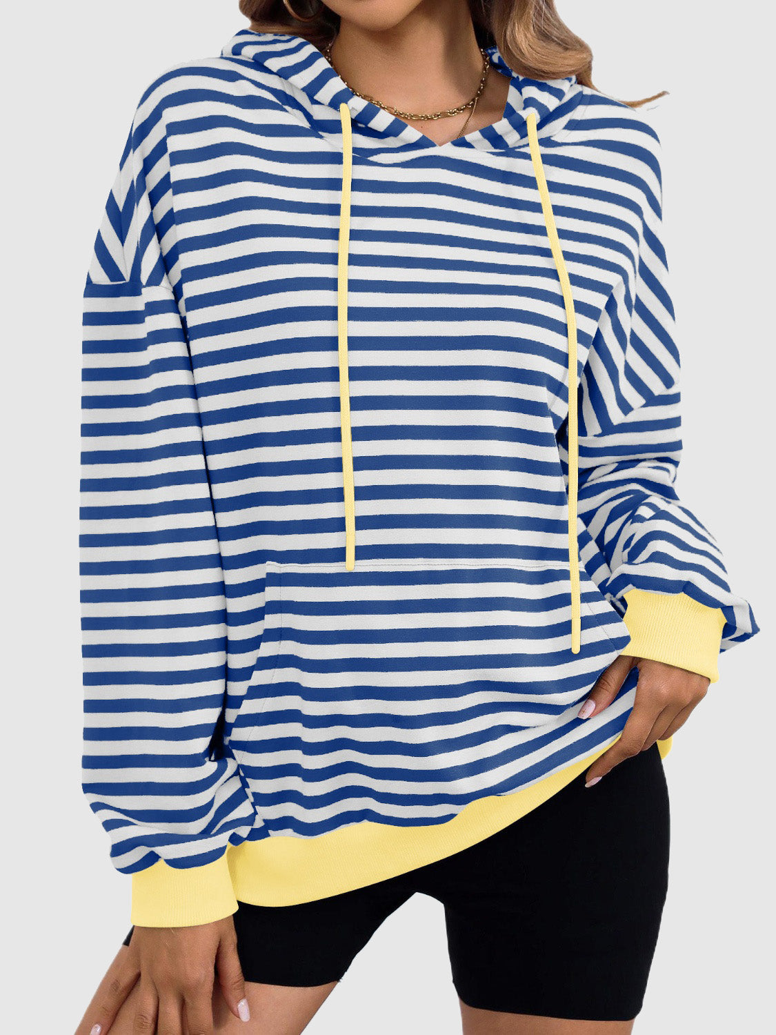 A stylish drawstring striped long sleeve hoodie in a casual setting, showcasing its comfortable fit and trendy design.