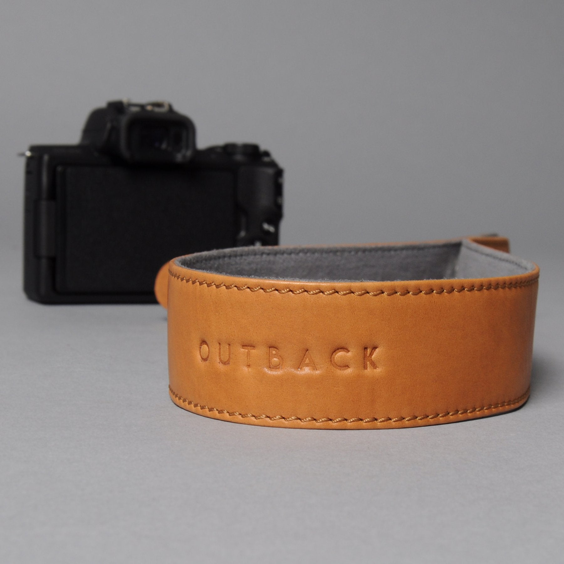 A stylish DSLR camera leather strap made from durable harness leather, featuring adjustable length and antique brass hardware.