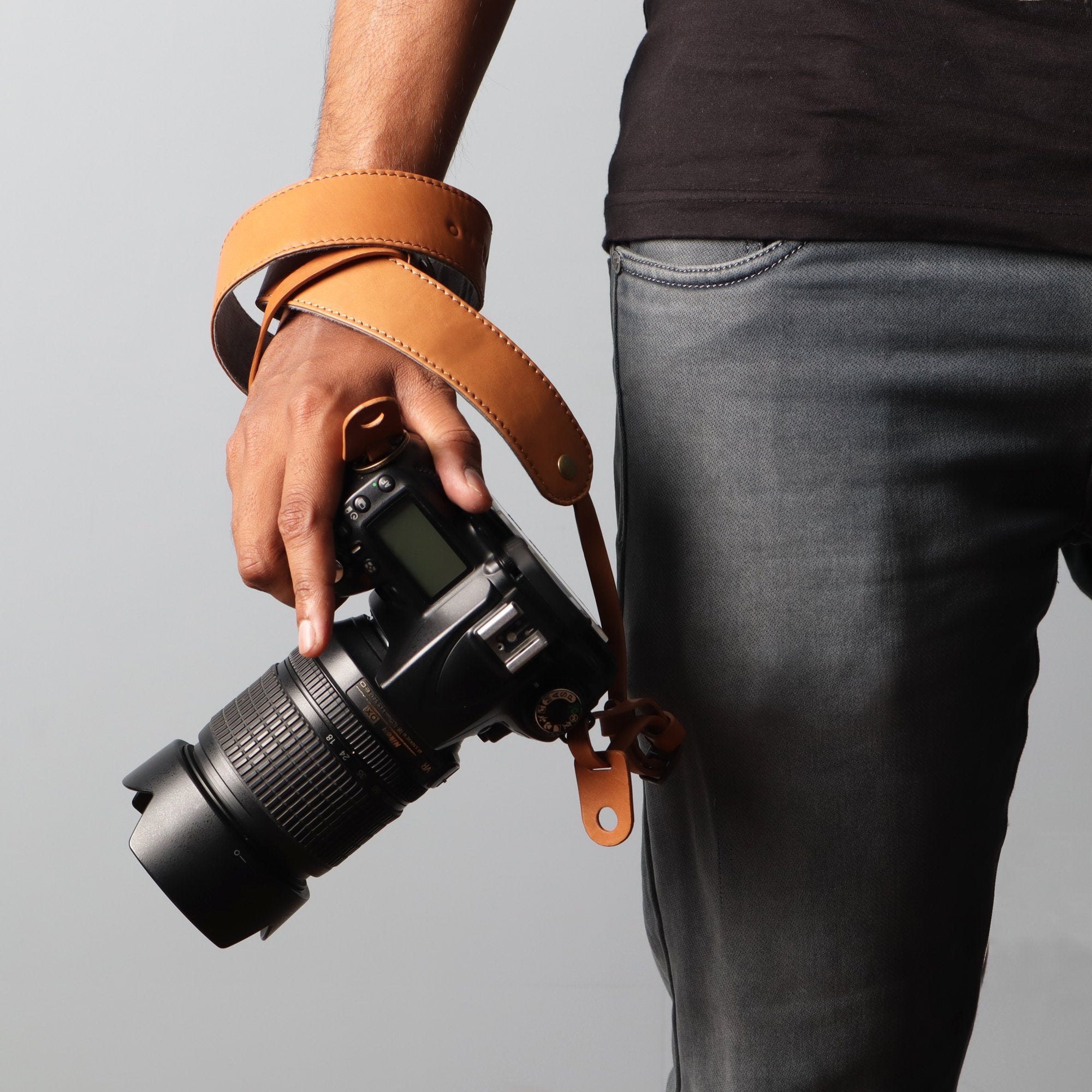 A stylish DSLR camera leather strap made from durable harness leather, featuring adjustable length and antique brass hardware.
