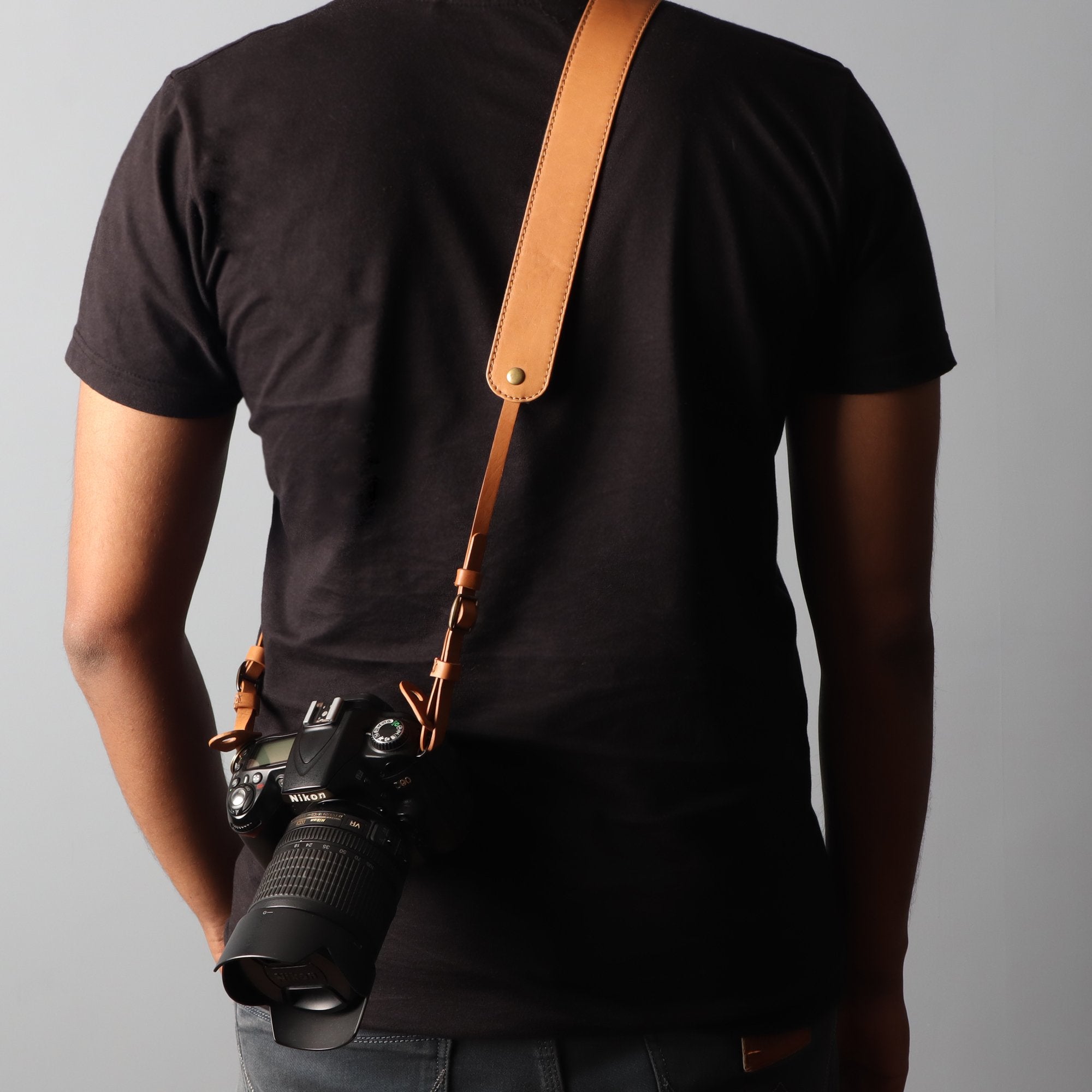 A stylish DSLR camera leather strap made from durable harness leather, featuring adjustable length and antique brass hardware.