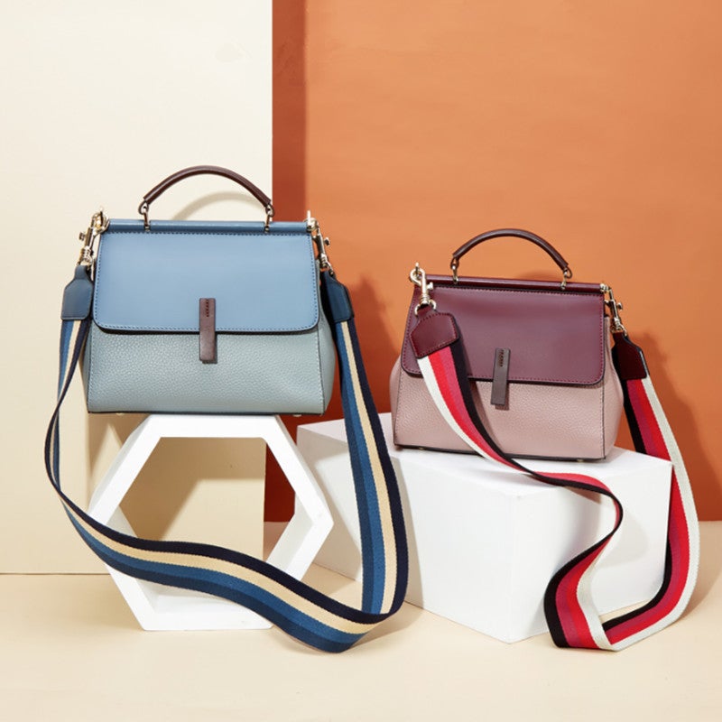 A stylish portable lady's small messenger bag made of two-layer cowhide leather, featuring a trendy splicing design and a wide shoulder strap.