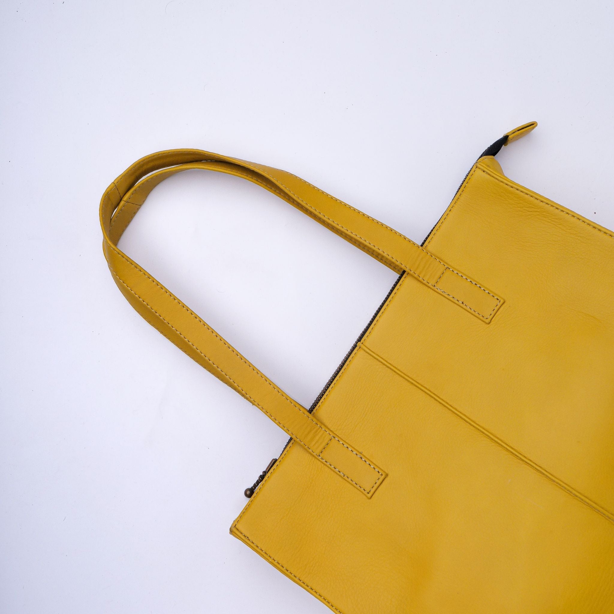 Everyday Women's Leather Zipper Tote Bag in Mustard Yellow, showcasing its spacious design and premium cow leather material.