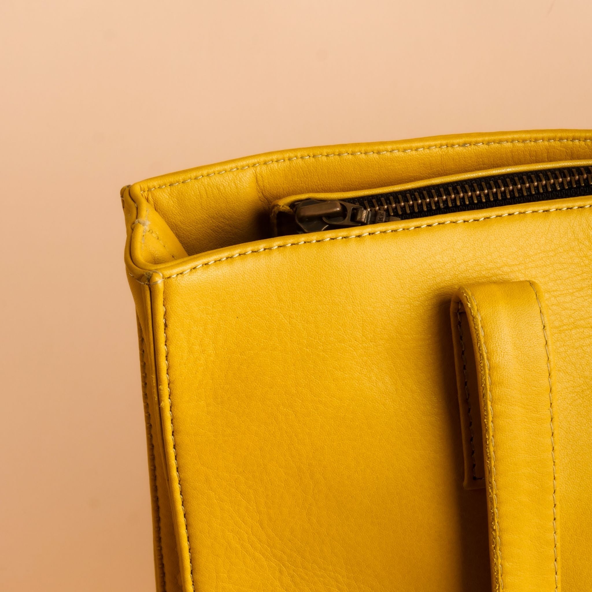Everyday Women's Leather Zipper Tote Bag in Mustard Yellow, showcasing its spacious design and premium cow leather material.