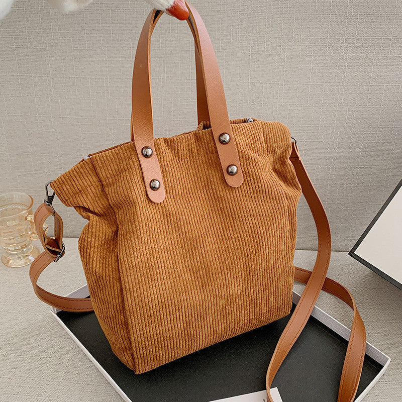Fashionable large-capacity shoulder bag made of corduroy, featuring a stylish western design and a comfortable shoulder strap.