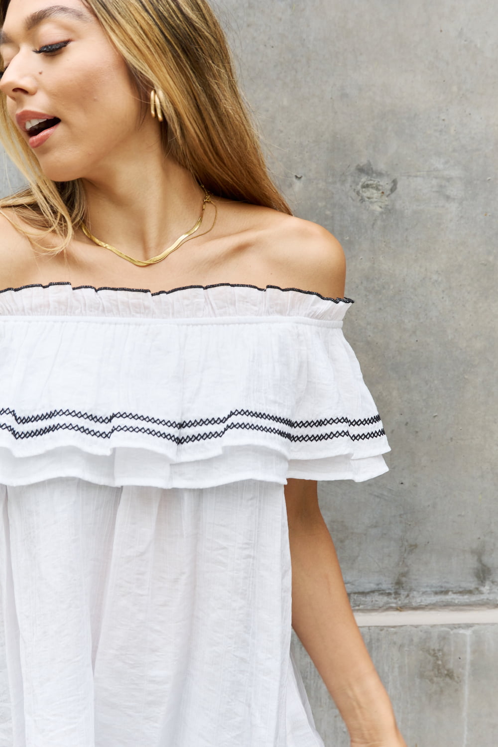 A stylish full size off-the-shoulder ruffle blouse featuring intricate embroidery and flutter sleeves, perfect for a chic look.