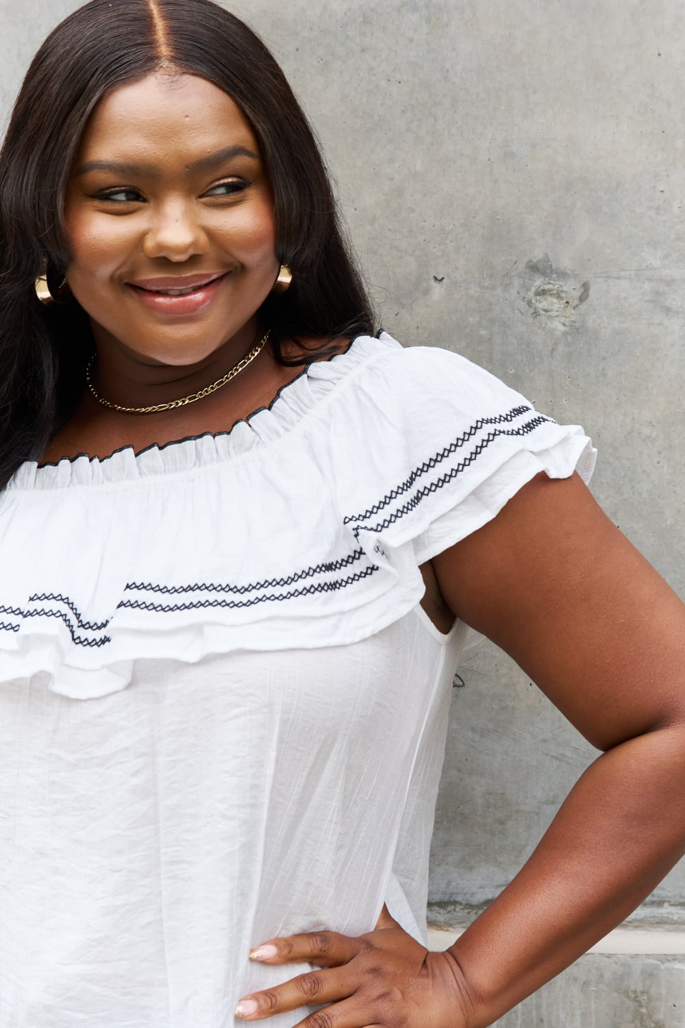 A stylish full size off-the-shoulder ruffle blouse featuring intricate embroidery and flutter sleeves, perfect for a chic look.