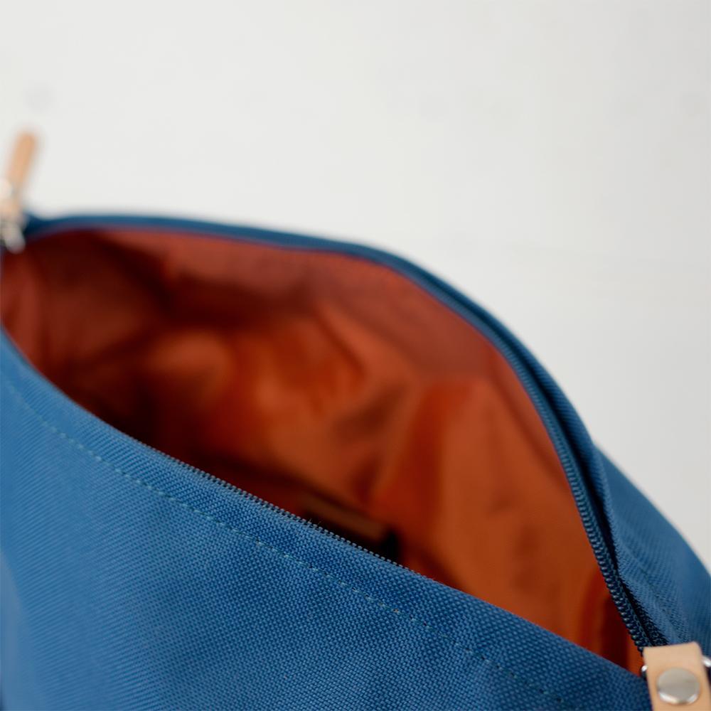 Highline Daypack in various colors with leather accents, showcasing its sleek design and multiple pockets.