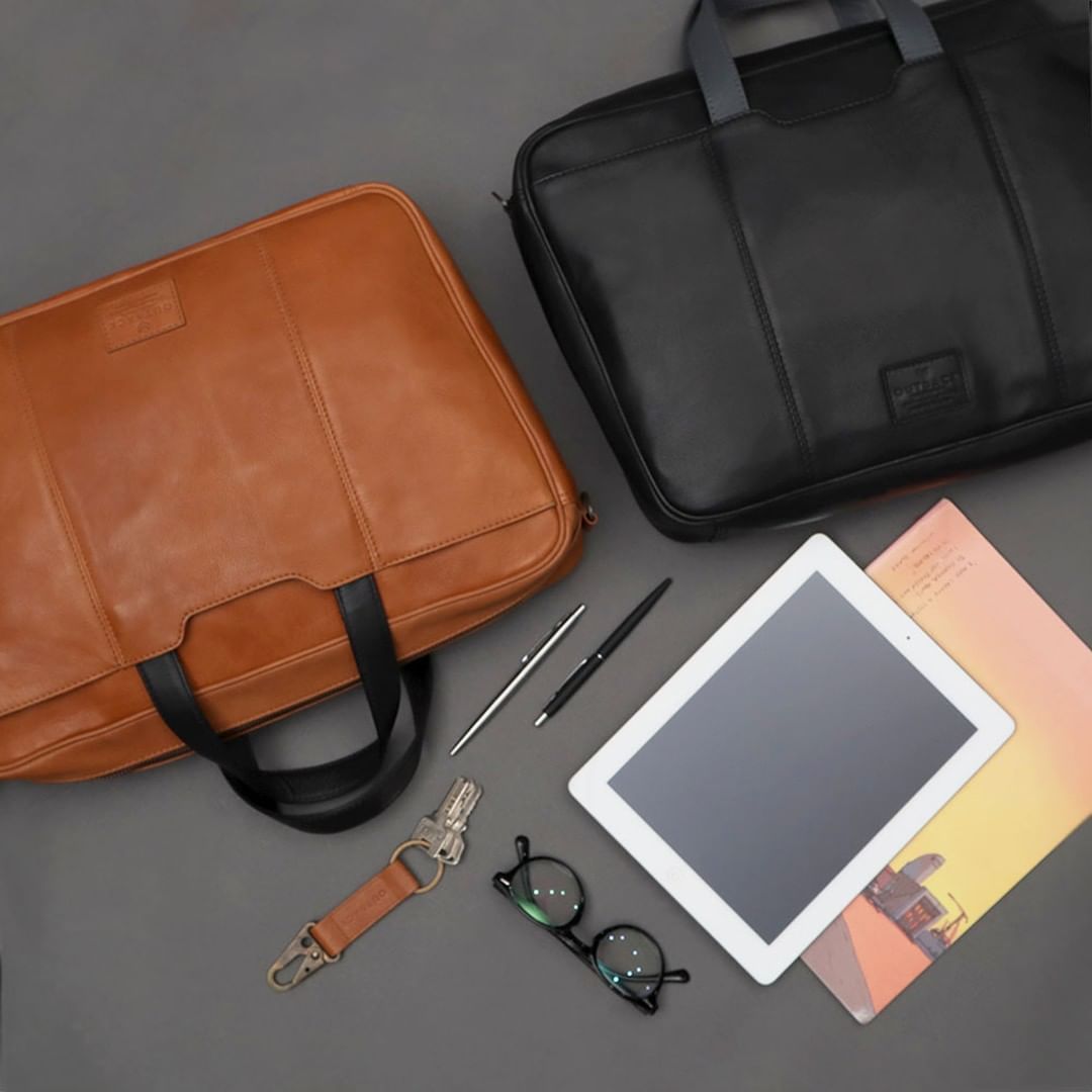 Hogan Leather Briefcase made from premium full grain leather, featuring multiple pockets and a padded laptop compartment, showcasing its elegant design.