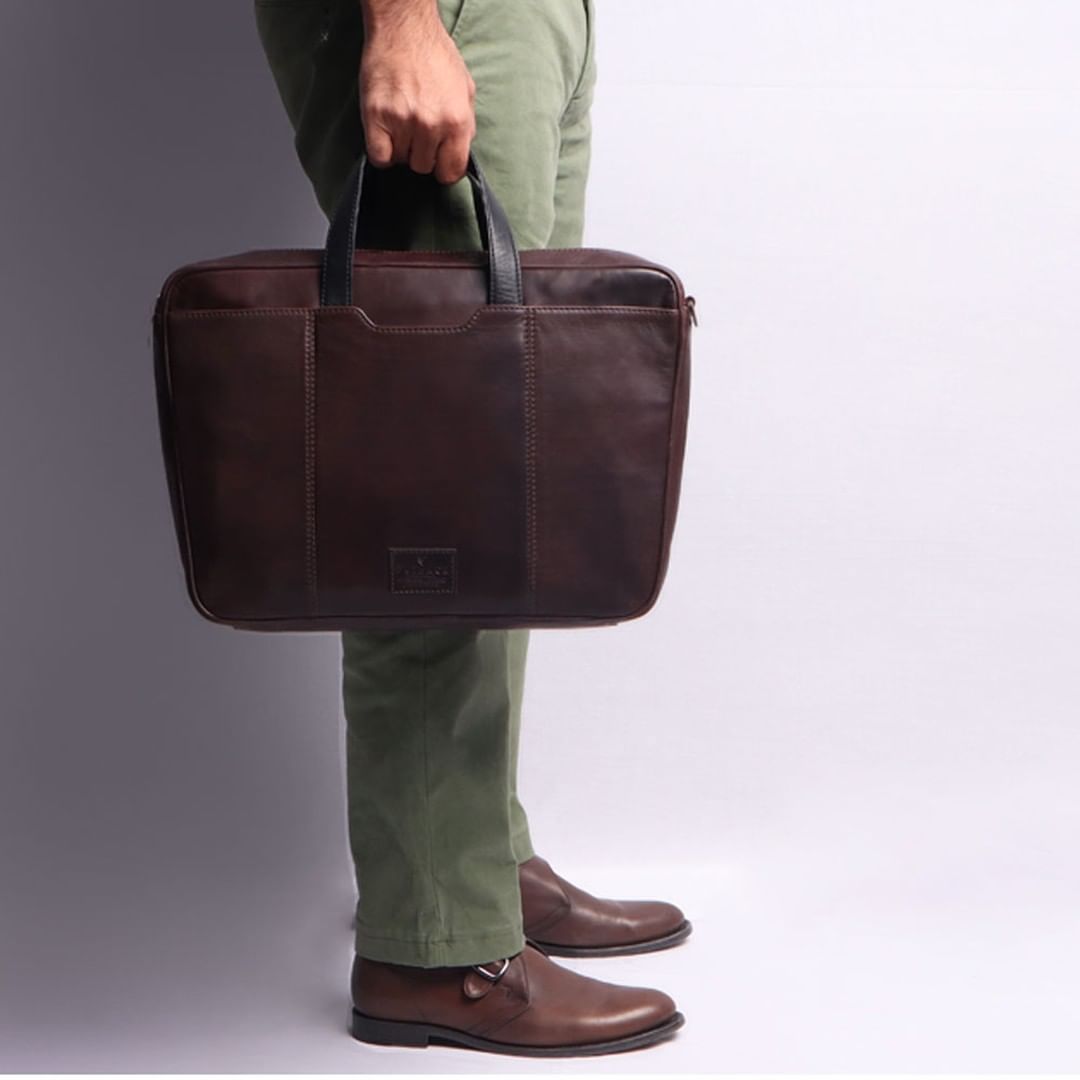 Hogan Leather Briefcase made from premium full grain leather, featuring multiple pockets and a padded laptop compartment, showcasing its elegant design.