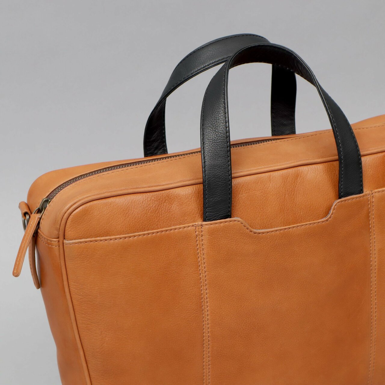 Hogan Leather Briefcase made from premium full grain leather, featuring multiple pockets and a padded laptop compartment, showcasing its elegant design.