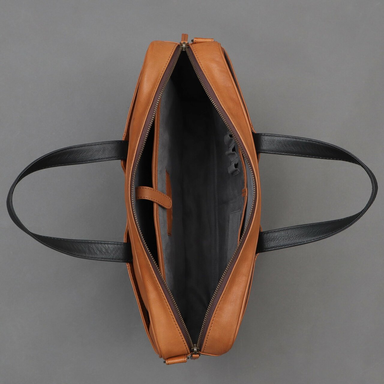 Hogan Leather Briefcase made from premium full grain leather, featuring multiple pockets and a padded laptop compartment, showcasing its elegant design.