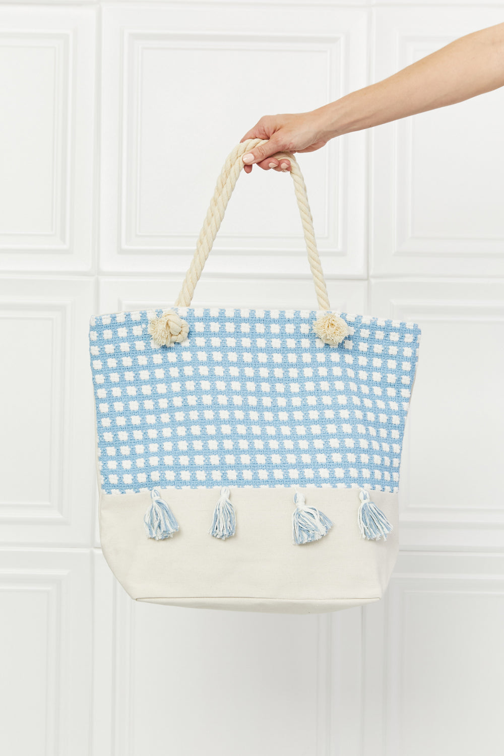 Justin Taylor Picnic Date Tassle Tote Bag featuring a plaid pattern and sturdy rope handles, ideal for beach and park outings.