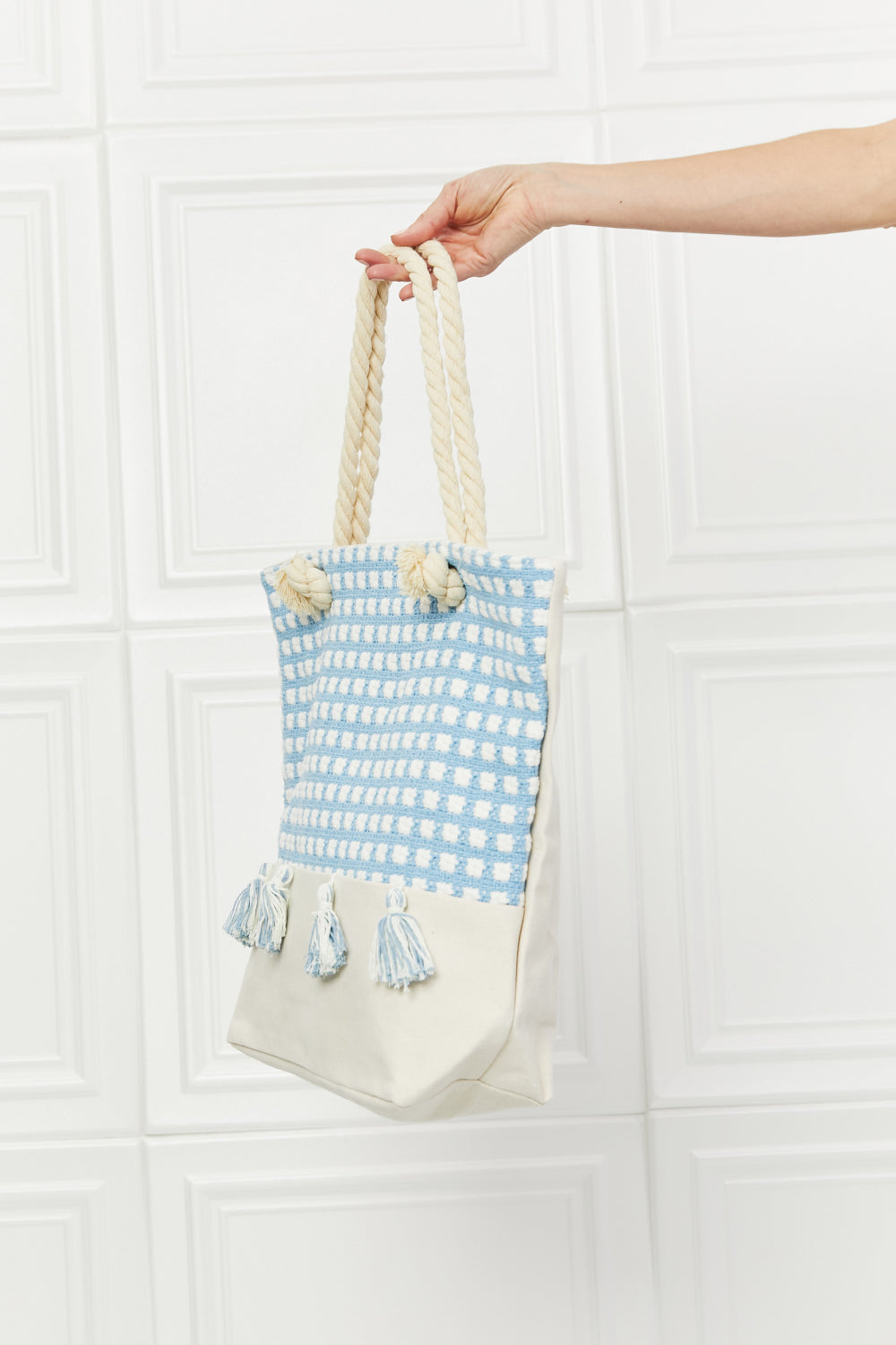 Justin Taylor Picnic Date Tassle Tote Bag featuring a plaid pattern and sturdy rope handles, ideal for beach and park outings.
