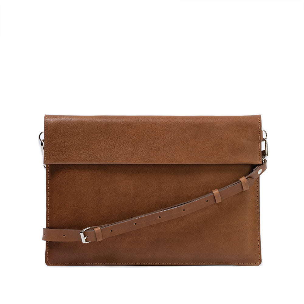 Elegant leather bag designed for iPad, featuring adjustable strap and magnetic closure, showcasing premium craftsmanship.